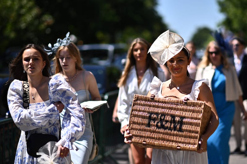 Race-goers arrive with a picnic basket. AFP