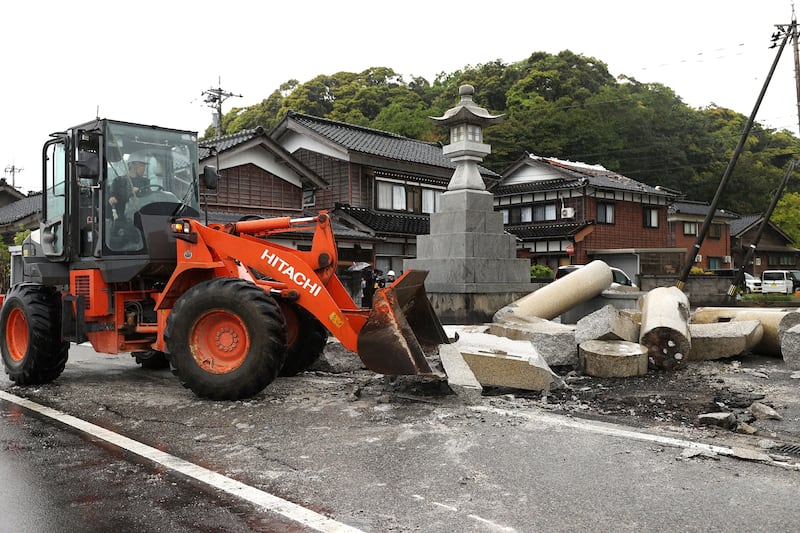 Heavy machinery is used to clear the fallen 'torii', or gate of Susu Shrine, on Saturday, after it collapsed when a 6. 5 magnitude earthquake hit the area of Suzu, Ishikawa prefecture. AFP