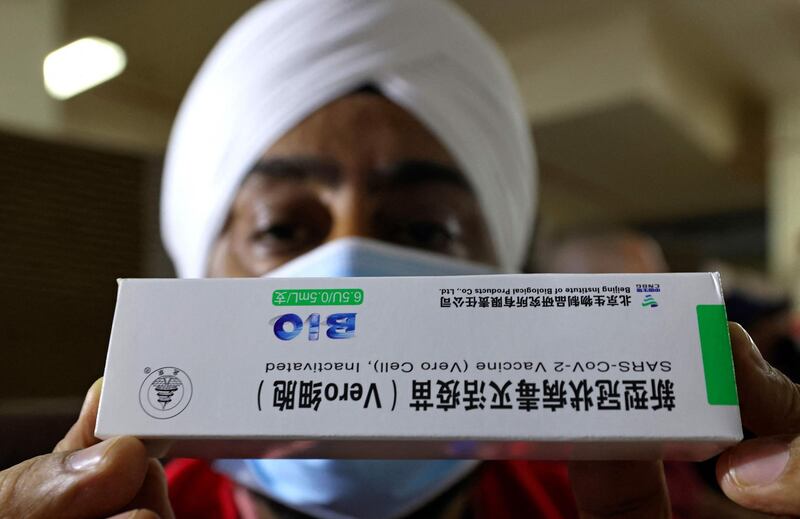 A Sikh healthcare worker studies a box of Sinopharm coronavirus vaccine vials at the Guru Nanak Darbar gurudwara (Sikh temple) in Dubai. Karim Sahib / AFP
