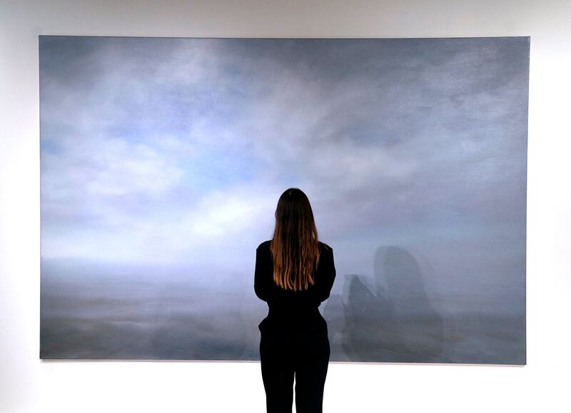 A woman poses in front of Gerhard Richter's 'Seestuck (Seascape)'. AFP
