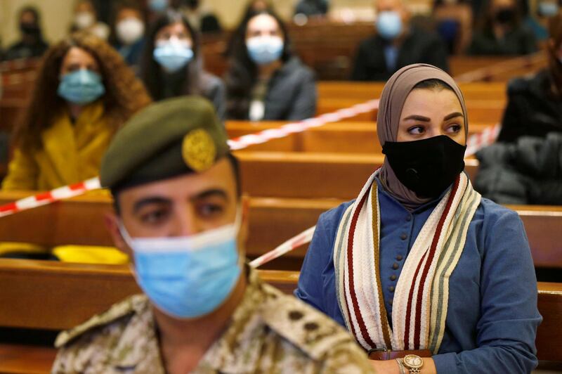 A Jordanian muslim woman and a soldier wearing protective masks and maintaining social distance attend a mass before the Christmas tree lighting ceremony, at Church of the Sacred Heart, amid fears over rising numbers of coronavirus disease cases in downtown Amman, Jordan. Reuters