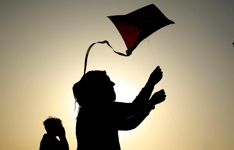 People take part in the kite festival as the sun sets in Baghdad, Iraq. AP