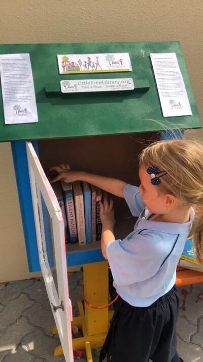 Kelly Harvarde and Alex Jeffries's daughter Aya organising the family's Little Free Library. Harvarde