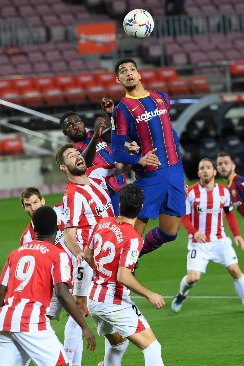 Athletic Bilbao's Spanish defender Yeray Alvarez , Barcelona's French defender Samuel Umtiti and Barcelona's Uruguayan defender Ronald Araujo jump for the ball during the Spanish league football match FC Barcelona against Athletic Club Bilbao at the Camp Nou stadium in Barcelona on January 31, 2021. (Photo by LLUIS GENE / AFP)