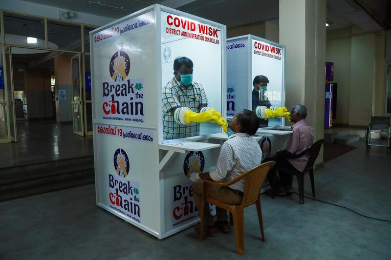 Medical staff collect samples from people at newly set upped Walk-In Sample Kiosk (WISK) to test for the COVID 19 coronavirus at Ernakulam Medical College in Kerala on April 6, 2020. / AFP / Arun CHANDRABOSE
