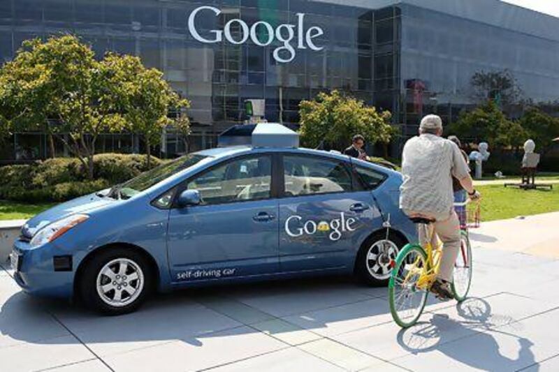 A cyclist passes a Google self-driving car. Such vehicles are a very realistic prospect over the next decade or two. Justin Sullivan / AFP