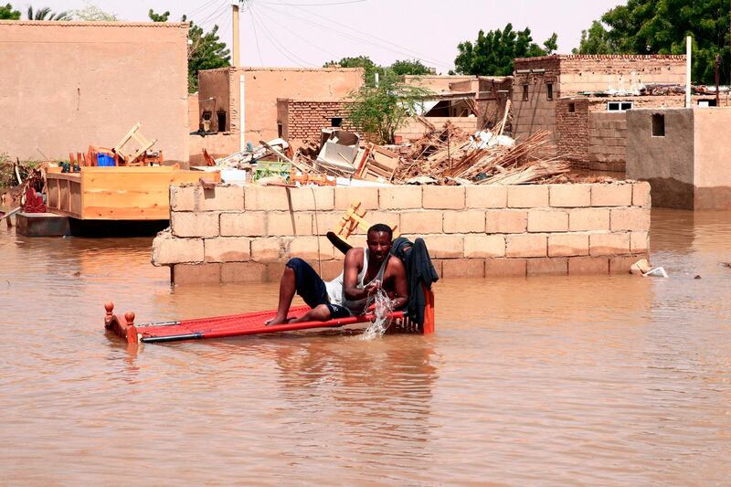 A Sudanese man sits on his bed amidst floods in Wad Ramli village on the eastern banks of the Nile river.  AFP