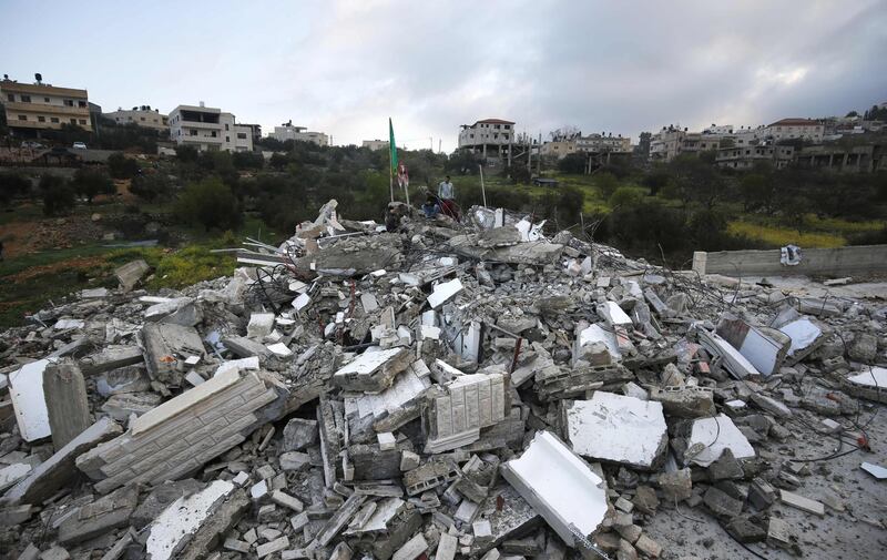 People stand on the rubble of the house of Palestinian Assam Barghouti, accused by Israel of shooting dead two soldiers in the West Bank after it was demolished by Israeli forces in the village of Kobar near Ramallah. AFP