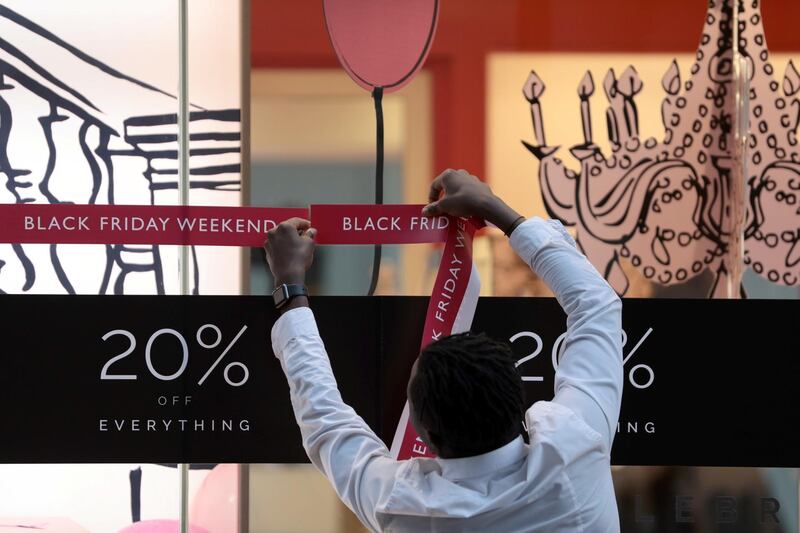 An shop assistant puts up a sign in a store on Oxford Street on 'Black Friday' in London. Simon Dawson / Reuters