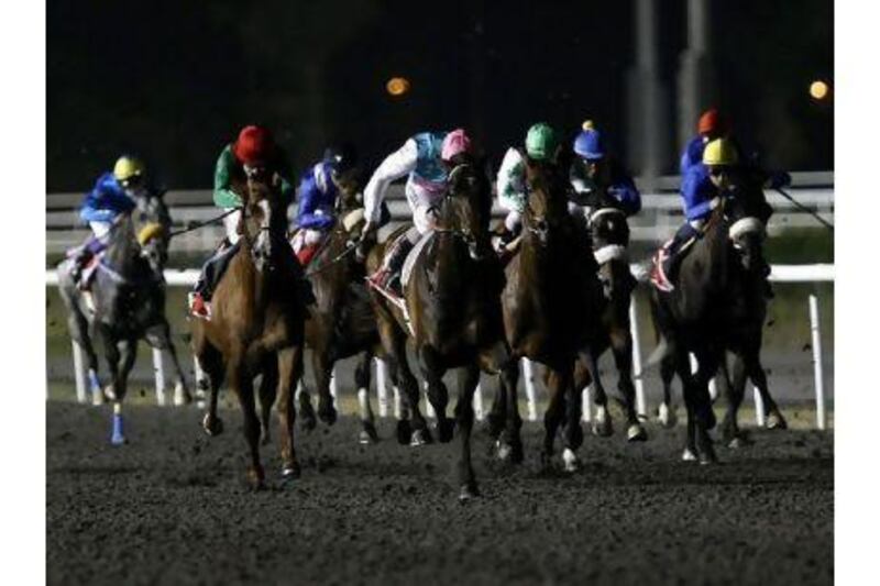 Tom Queally, in the pink helmet, rides Twice Over to victory in the Al Maktoum Challenge Round three  at Meydan Racecourse on Thursday night.