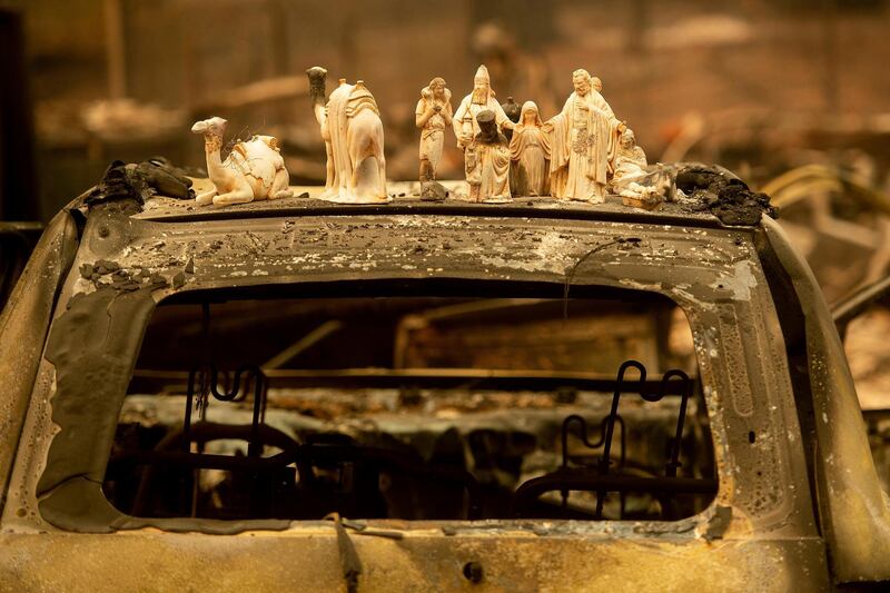 Following the Camp Fire, figurines rest atop a scorched car in Paradise. AP Photo