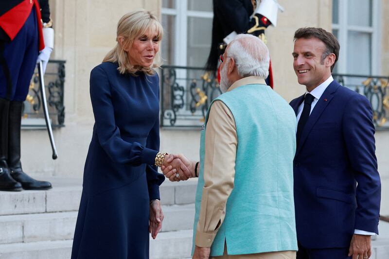 Mr Macron stands by as his wife Brigitte greets Mr Modi at the Elysee Palace. Reuters