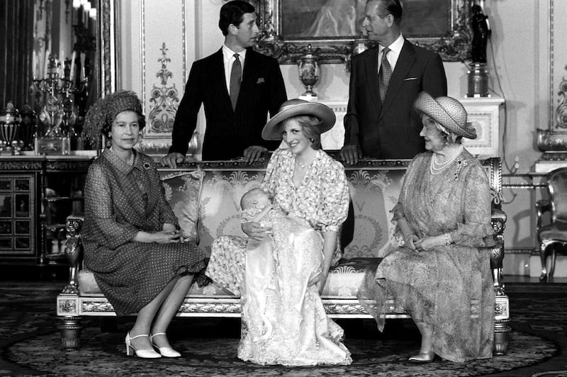 Princess Diana,holds her son Prince William in her arms in the White Drawing Room of Buckingham Palace following a private christening ceremony in the Music Room. She is surrounded by family members: Back row left to right: Pricne Charles, Prince Philip, the Duke of Edinburgh. Seated front left to right: Queen Elizabeth II and Queen Elizabeth, the Queen Mother. The Prince was christened in the traditional gown of Honiton lace. 4th August 1982. (Photo by Kent Gavin  /Mirrorpix/Getty Images)