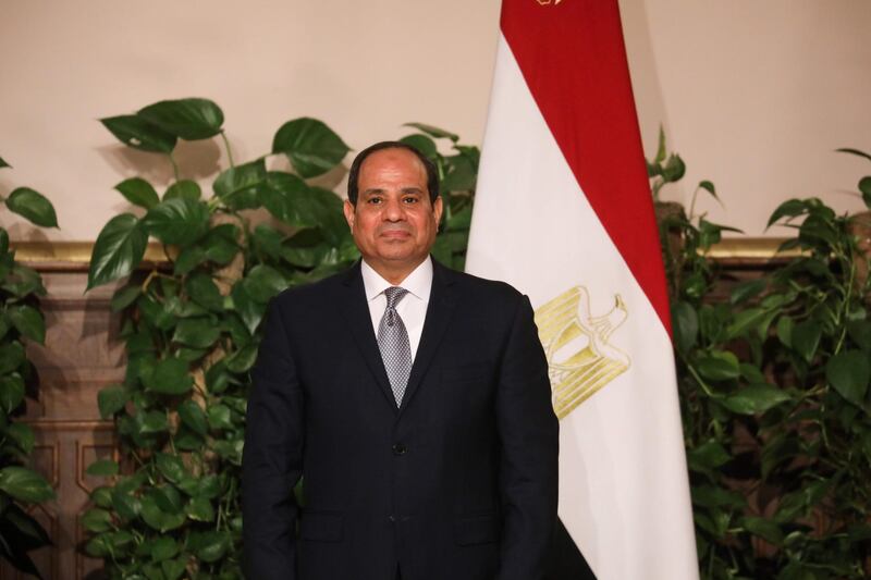 Egyptian President Abdel Fattah Al-Sisi stands in front of an Egyptian flag as various Egyptian and French ministers sign cooperation agreements at the presidential palace in Cairo on January 28, 2019. Sis and his French counterpart Emmanuel Macron oversaw the signing of around 30 deals between Egypt and France worth several hundred million euros (dollars). / AFP / Ludovic MARIN
