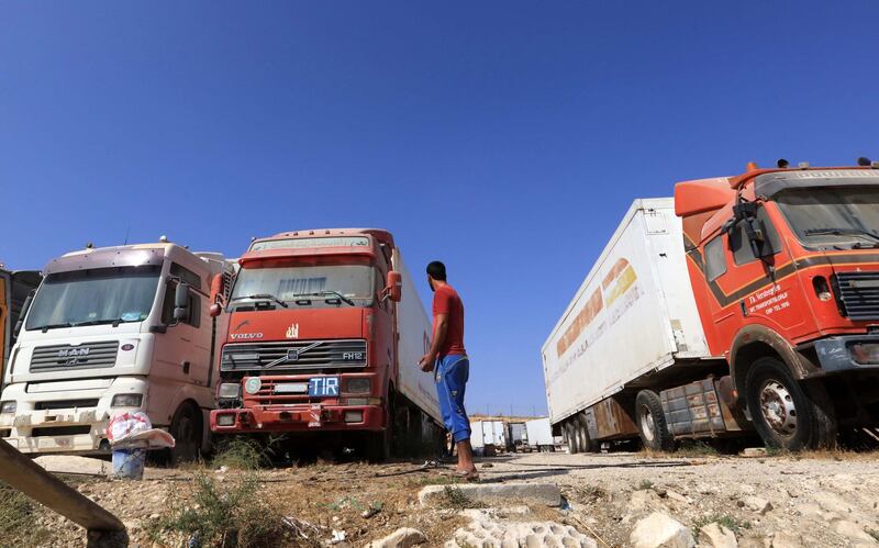 A man waits near trucks parked near Jaber-Nassib border crossing between Syria and Jordan. EPA