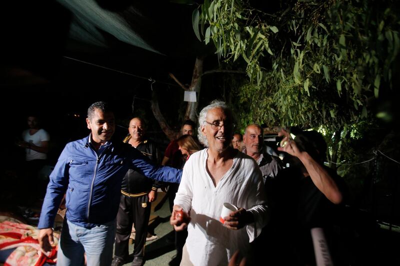 Frank Roimano, an American-French law professor, arrives to the West Bank Bedouin community of Khan al-Ahmar after he has been released from Israeli police custody , Monday, Sept. 17, 2018. Israel has released Romano detained for allegedly trying to block Israeli troops in a West Bank village slated for demolition. Romano's lawyer, said a court ordered his release Sunday. She said he was freed early Monday after police decided not to appeal the decision. (AP Photo/Nasser Shiyoukhi)