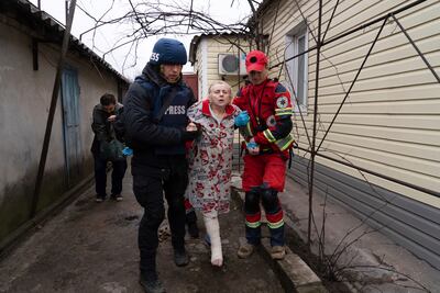 Associated Press photographer Evgeniy Maloletka helps a paramedic to transport a woman injured during shelling in Mariupol. AP Photo