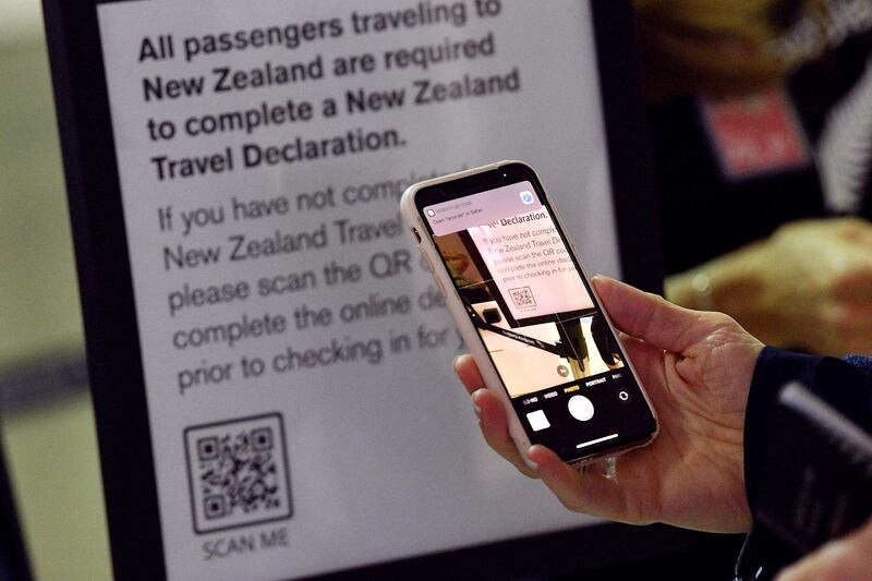 A passenger scans a barcode to complete travel declarations for New Zealand flights at Sydney International Airport. AFP