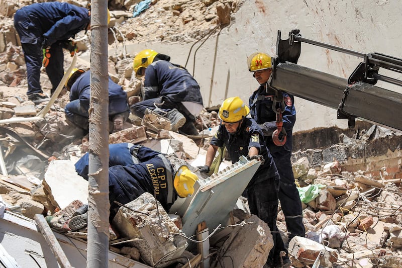 First responders search through rubble at the scene in the Sidi Bishr district. AFP