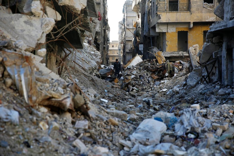 A man walks through rubble in the Salaheddine neighborhood in the eastern Aleppo, Syria, Saturday, Jan. 20, 2018. Turkey's military fired into a Kurdish-run enclave in north Syria for a second day on Saturday, one day after the country's defense minister announced an operation to "cleanse" the Kurdish militia in control of the enclave. (AP Photo/Hassan Ammar)