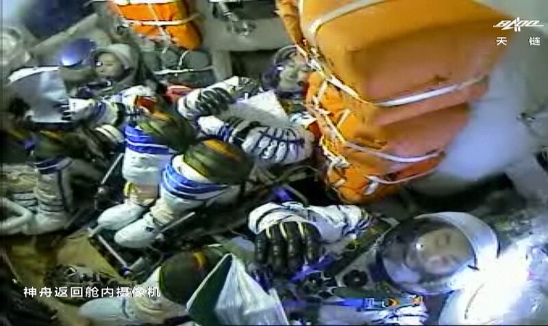 This screen grab made from a video released by Chinese state broadcaster CCTV shows, left to right, Chinese astronauts Wang Yaping, Zhai Zhigang and Ye Guangfu inside the return capsule of the Shenzhou-13 spacecraft. AFP