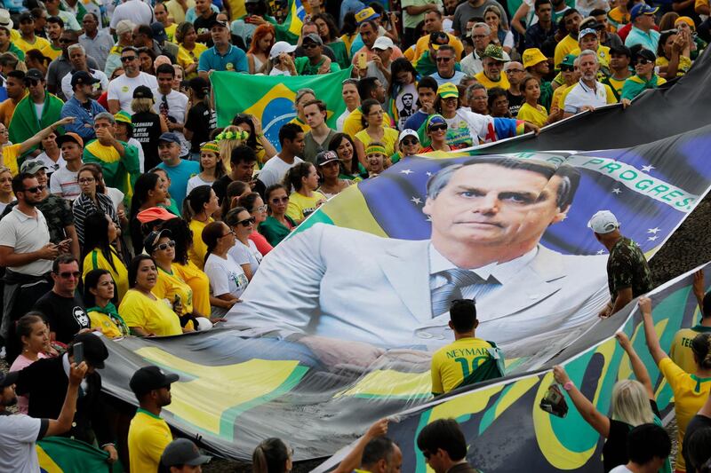 Supporters display a giant banner with the likeness of Brazil's new President Jair Bolsonaro,. AP