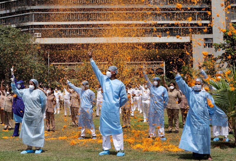 An Indian Air Force helicopter showers flower petals on the staff of INS Ashvini hospital in Mumbai, India as part of Armed Forces' efforts to thank doctors, nurses and police personnel at the forefront of the country's battle against the Covid-19 pandemic, May 3, Mumbai, India. Rajanish Kakade / AP