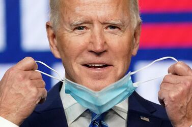 Democratic US presidential nominee and former Vice President Joe Biden smiles as he pulls off his face mask to speak about the results of the election. Reuters