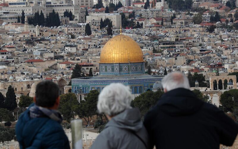 Tourists look at the Old City of Jerusalem and its Dome of the Rock mosque from the Mount of Olives on December 6, 2019.  / AFP / EMMANUEL DUNAND
