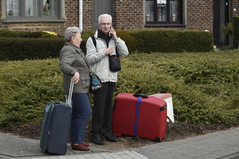 Two passengers wait, near Brussels airport in Zaventem following its evacuation after at least 13 people were killed and 35 injured as twin blasts rocked the main terminal of Brussels airport. John Thys / AFP
