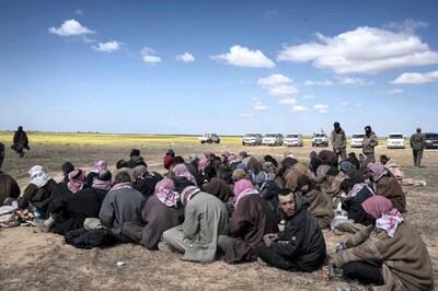 Men who surrendered to Syrian Democratic Forces waited ot be transported to prison, outside Baghouz, Syria, 8 March 2019.