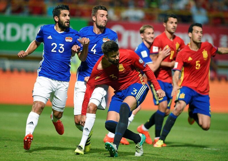 Spain defender Gerard Pique in action against Liechtenstein’s Michele Polverino, left, and Daniel Kaufmannin. Eloy Alonso / Reuters