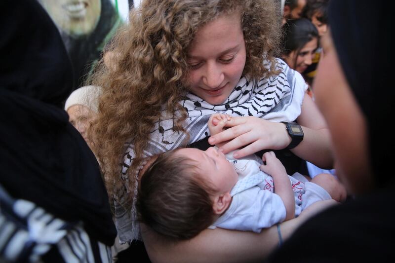 Ahed holds her cousin's baby who was born while she was in prison.