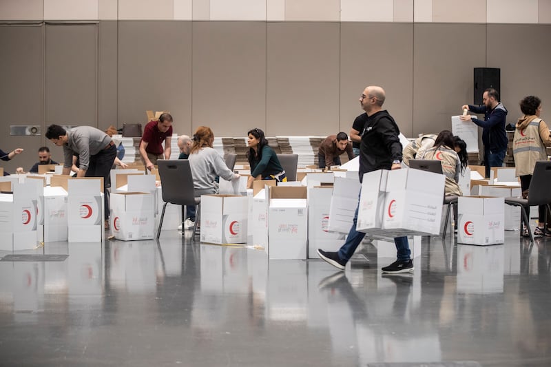 Volunteers pack food, blankets and other essential goods at the Dubai Exhibition Centre, at Expo City