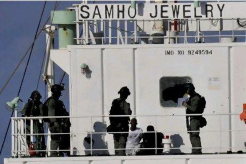 South Korean naval special forces stand guard over Somali pirates after detaining them on the South Korean cargo ship Samho Jewelry in the Arabian Sea in January this year. In a daring raid, South Korean special forces stormed the hijacked freighter in the Arabian Se, rescuing all 21 crew members and killing eight assailants. South Korean navy via Yonhap/ AP Photo