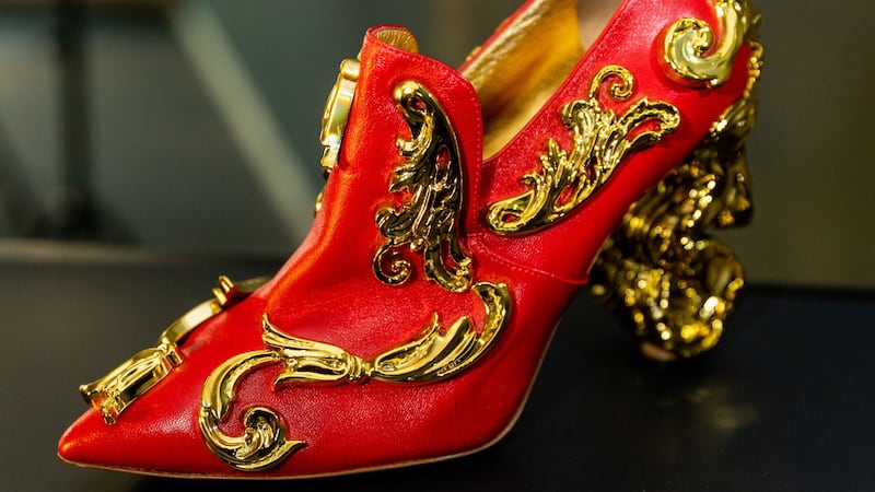 A red satin and golden shoe by Moschino on display in Abu Dhabi. Photo: Italian Cultural Institute