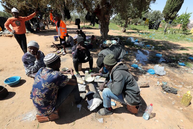 Sub-Saharan African migrants cook at a camp in Jebeniana, in Tunisia's Sfax province. Sfax is one of the main departure points for irregular migration to Europe. EPA