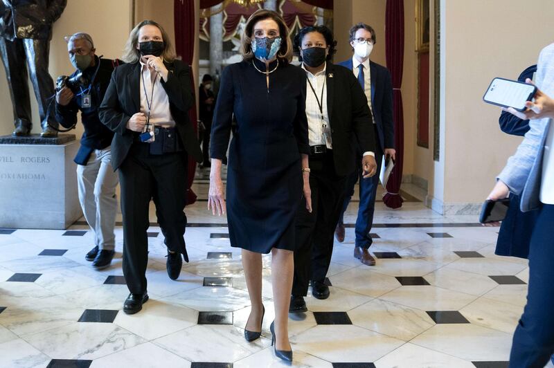 WASHINGTON, DC - JANUARY 13: Speaker of the House Nancy Pelosi (D-CA) (C) wears a protective mask while walking to the House Floor at the U.S. Capitol on January 13, 2021 in Washington, DC. The House of Representatives is expected to vote to impeach President Donald Trump later today, after Vice President Mike Pence declined to use the 25th amendment to remove him from office after protestors breached the U.S. Capitol last week.   Stefani Reynolds/Getty Images/AFP
== FOR NEWSPAPERS, INTERNET, TELCOS & TELEVISION USE ONLY ==

