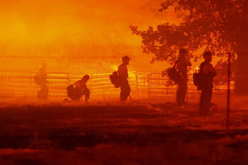 Firefighters look on as the Oak Fire burns in Darrah, Mariposa county. Reuters