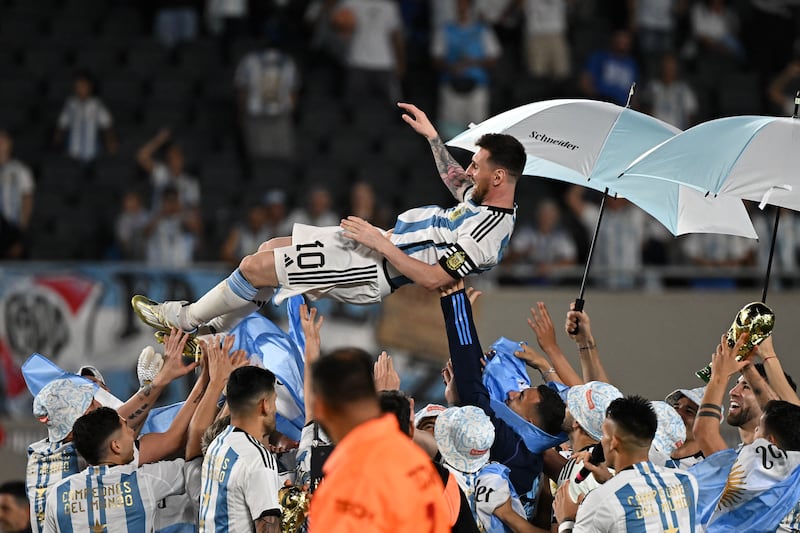 Argentina forward Lionel Messi is lifted up by teammates during a recognition ceremony. AFP
