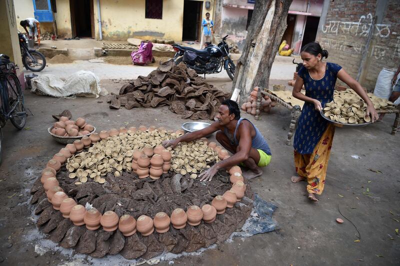 A potter loads dried clay earthen lamps into a furnace in Allahabad. AFP