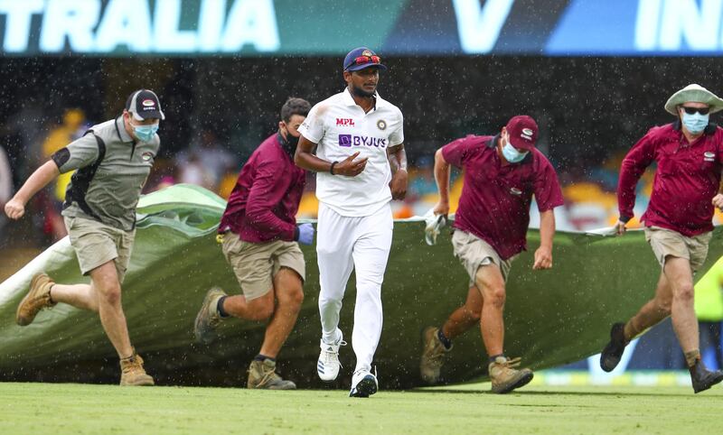 India's Thangarasu Natarajan runs from the field as rain stops play. AP