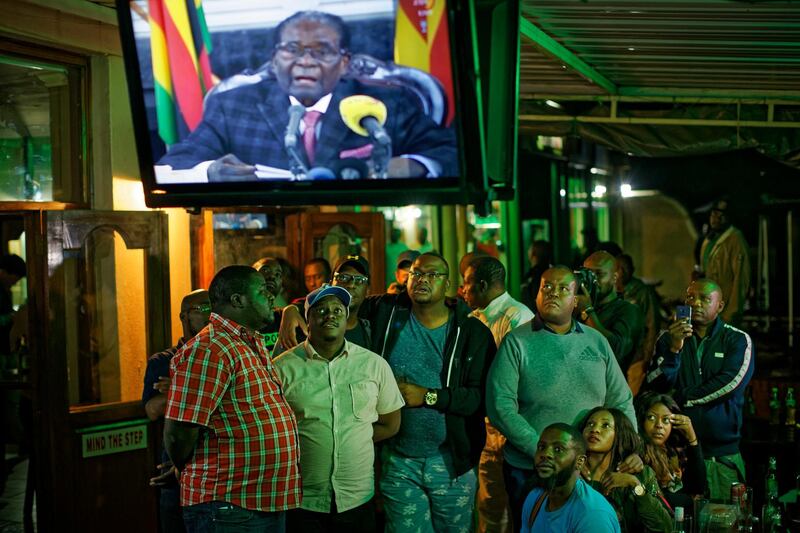 Zimbabweans watch a televised address to the nation by President Robert Mugabe at a bar in downtown Harare, Zimbabwe Sunday, Nov. 19, 2017. Zimbabwe's President Robert Mugabe has baffled the country by ending his address on national television without announcing his resignation. (AP Photo/Ben Curtis)