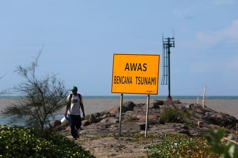 A man walks past a tsunami warning sign in Banda Aceh, Indonesia.  EPA
