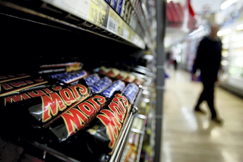 SYDNEY, NSW - AUGUST 18:  A customer walks past a Mars and Snickers Bar display in a supermarket August 18, 2005 in Sydney, Australia. Mars and Snickers bars returned to NSW shops today after extortion threats forced a mass recall of the chocolate bars last month. Makers MasterFoods received threatening letters; one of which contained a contaminated Snickers bar and another said there were seven contaminated bars in shops, forcing the company to recall and destroy more than three million Mars and Snickers bars.  (Photo by Ian Waldie/Getty Images)