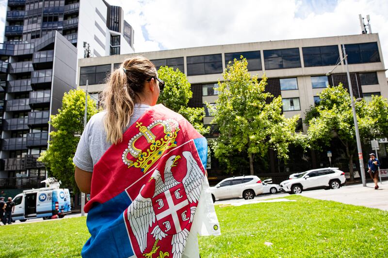 A supporter of Novak Djokovic wears a Serbia flag as she waits outside Park Hotel where Djokovic was taken pending his removal from the country after his visa was cancelled by the Australian Border Force. Getty Images