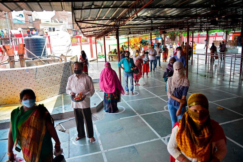 Hindu devotees wait in line to offer prayers at the Alopidevi temple in Allahabad on June 8, 2020. / AFP / SANJAY KANOJIA