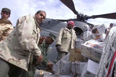 United Arab Emirates Air Force personnel load neck braces into a helicopter for a flight up to the Kosovar refugee camps in northern Albania 25 April, 1999. The hundreds of thousands of refugees are affected by injuries, difficult living conditions and unsanitary camps. (ELECTRONIC IMAGE) (Photo by MIKE NELSON / AFP)