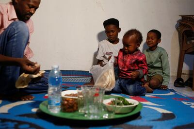 Mohamed Ismail, 42, who fled from the Sudanese civil war, eats a meal with his family in Cairo. Reuters