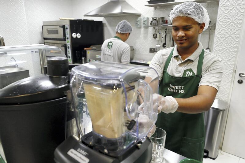 Abu Dhabi, United Arab Emirates - September 15, 2019: Chef Manoj creates a mango smoothie. A look at the newly opened Sweet Greens café. They have a special focus on being healthy and environmentally friendly. Sunday the 15th of September 2019. Rihan Heights, Abu Dhabi. Chris Whiteoak / The National